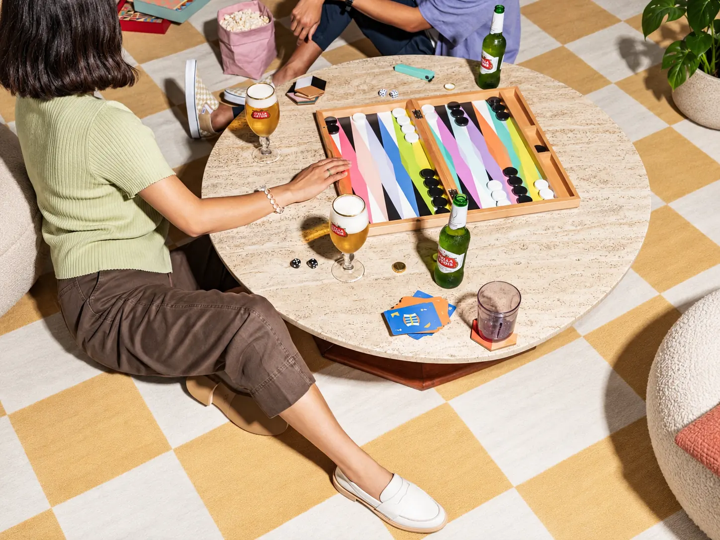 Friends playing a colourful backgammon game around a table