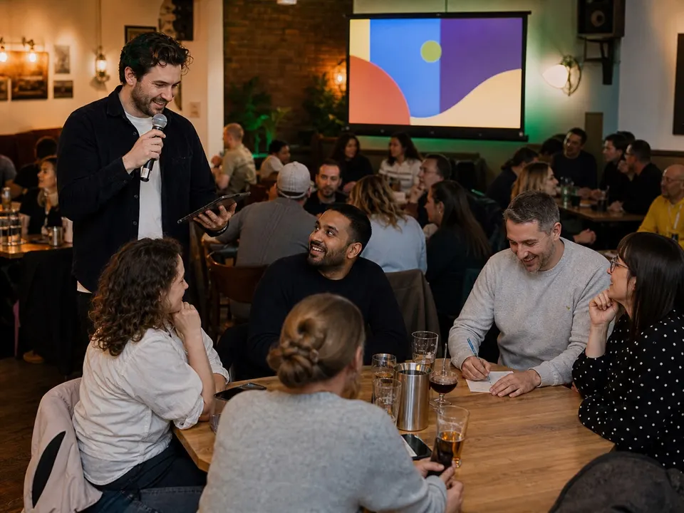 A professional quiz host running a live game for teams