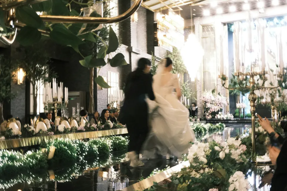 A bride and groom walking down the aisle at their wedding reception