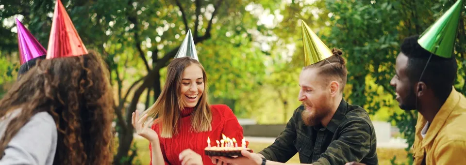 Friends celebrating together at a birthday party outdoors