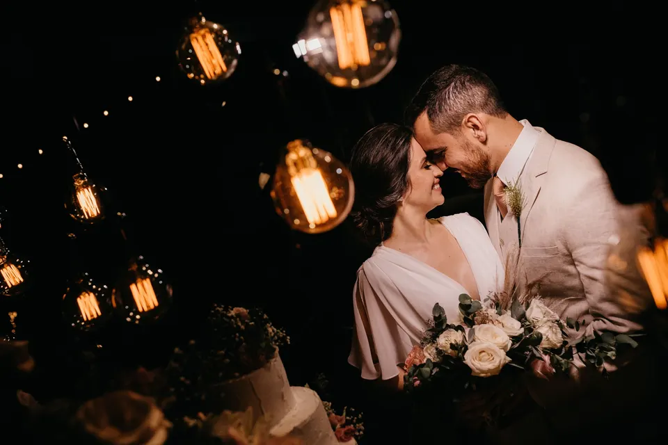 A bride and groom beneath warm pendant lights